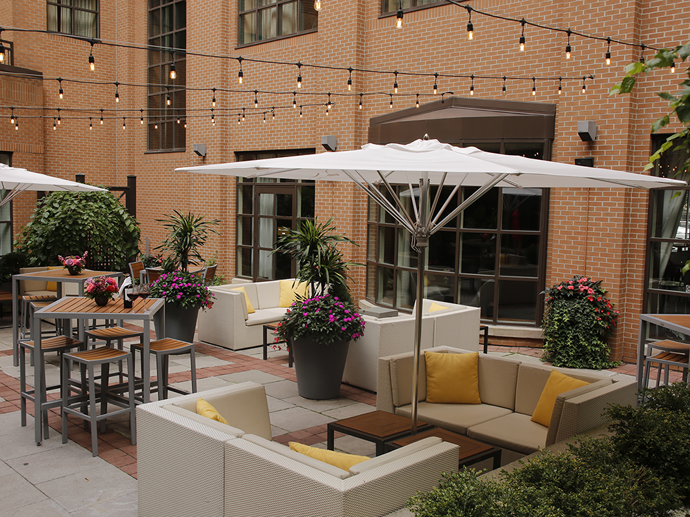An outdoor patio with tables and seating areas at The Yorkville Royal Sonesta Hotel Toronto.
