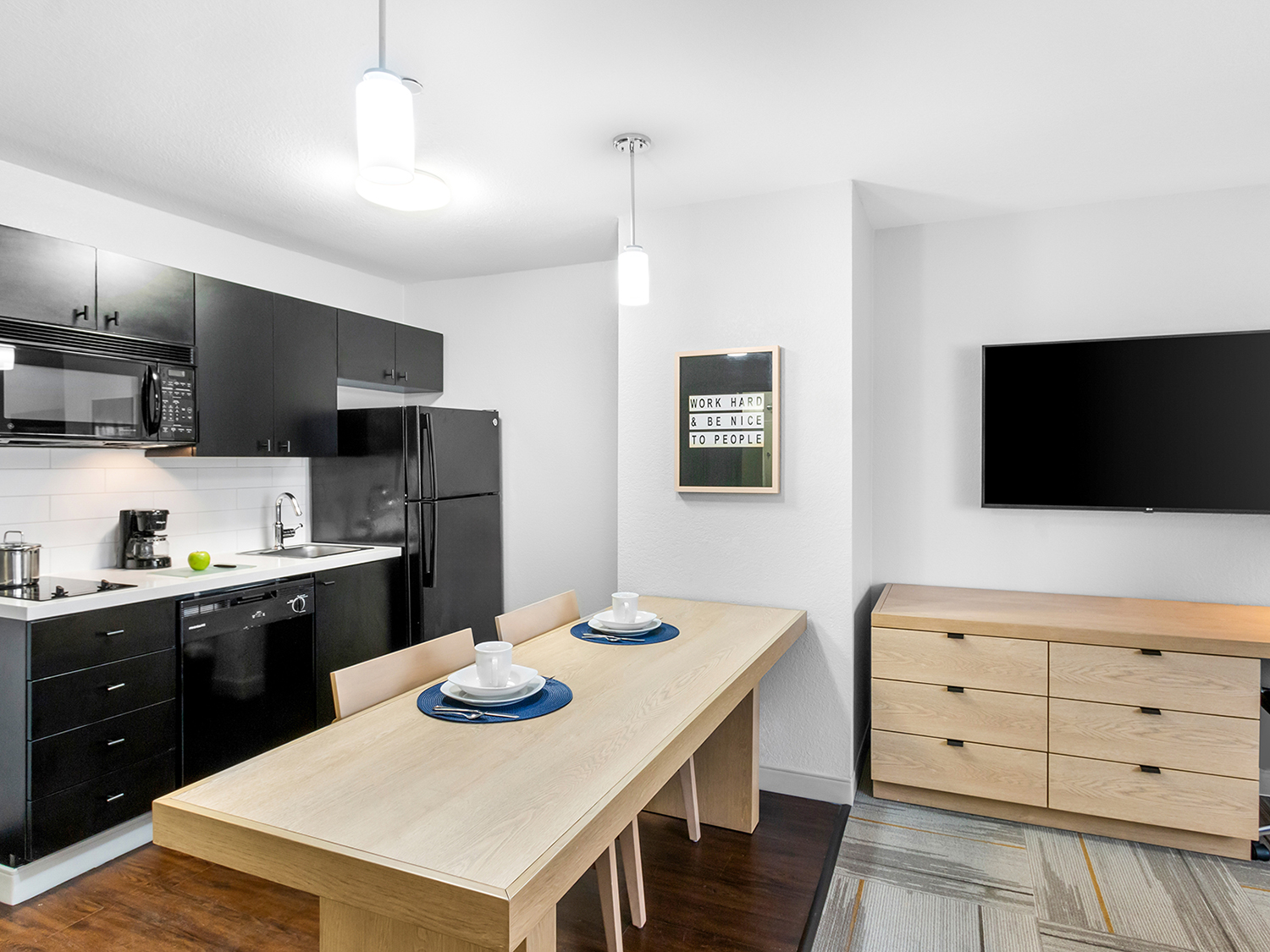 Modern dining area with kitchenette and TV.
