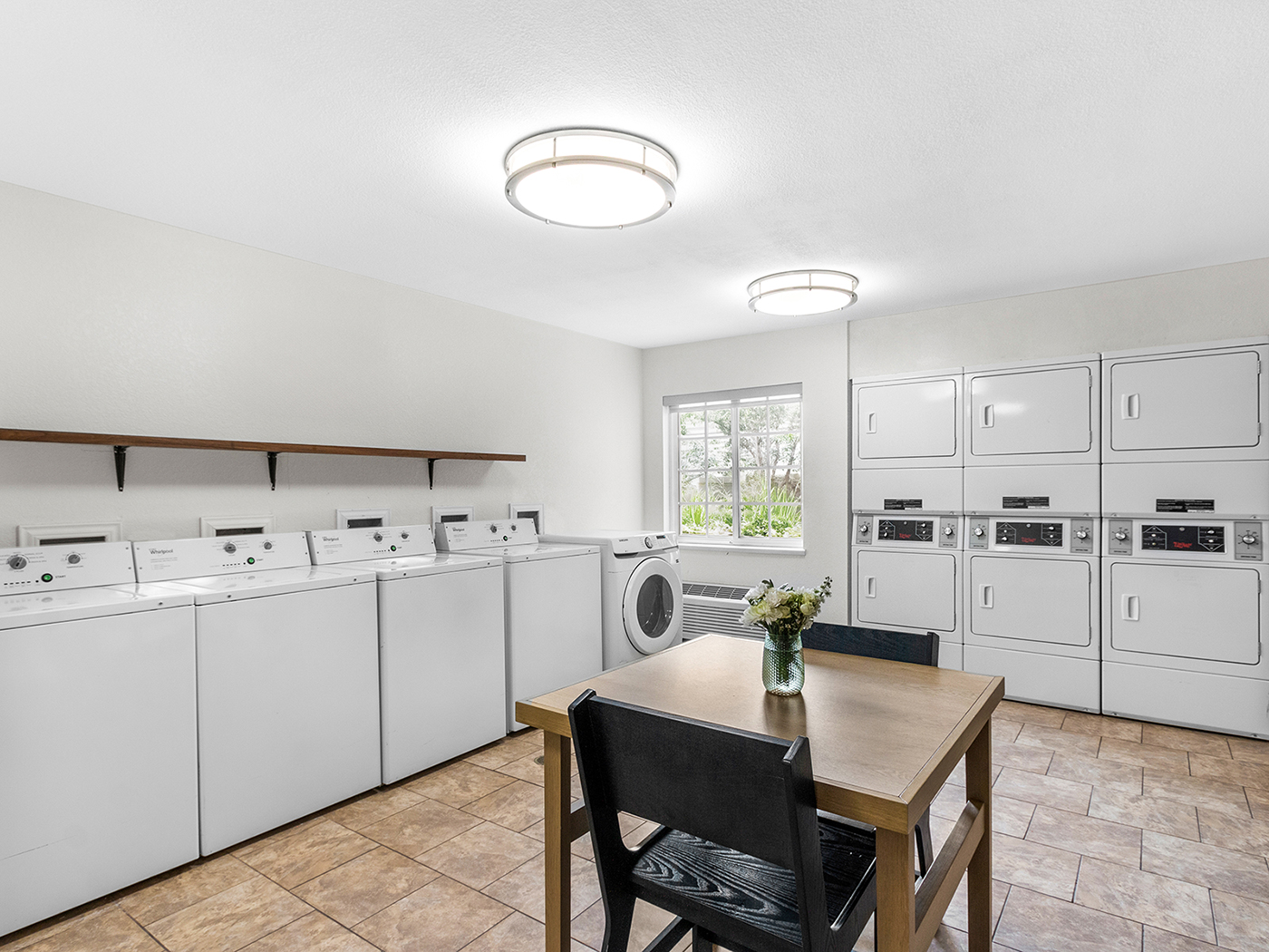 Laundry room with washers, dryers, and folding table.