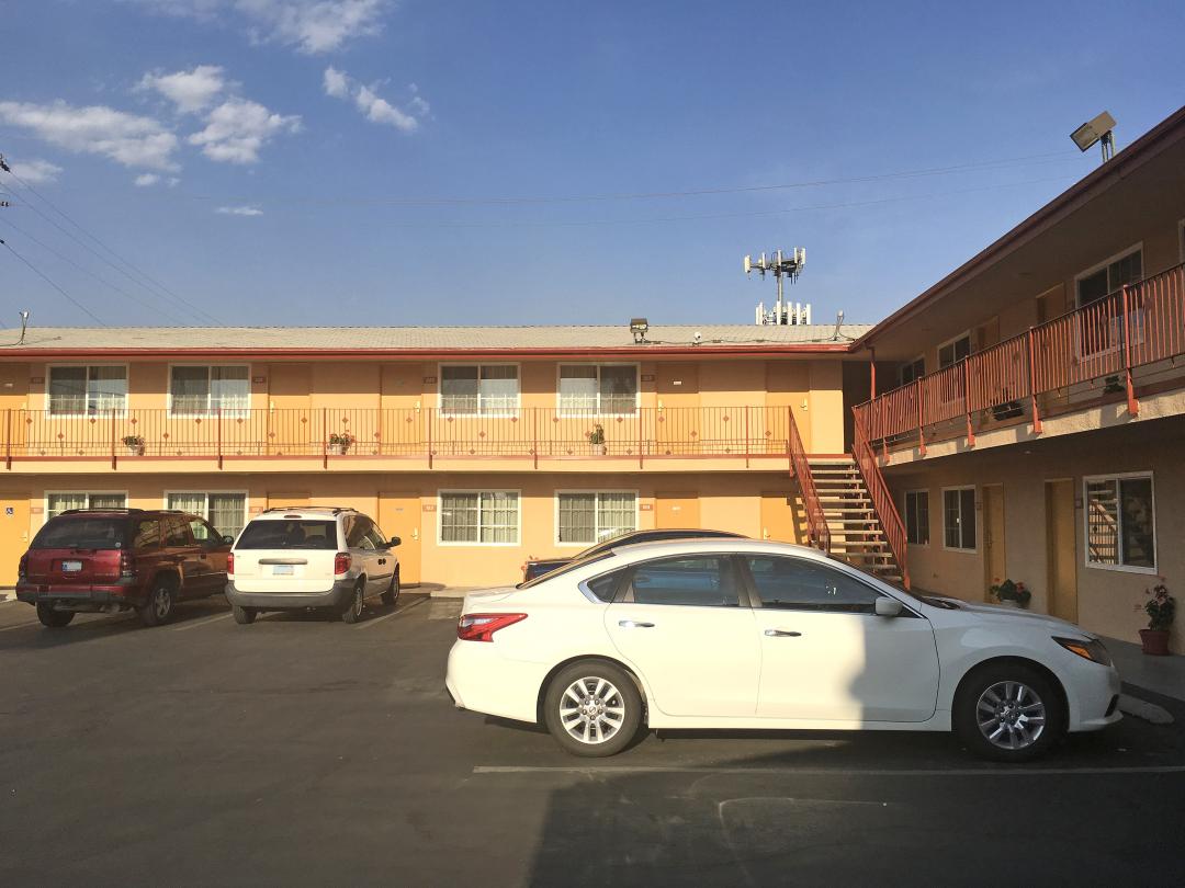 Hotel exterior view of guest rooms and parking area