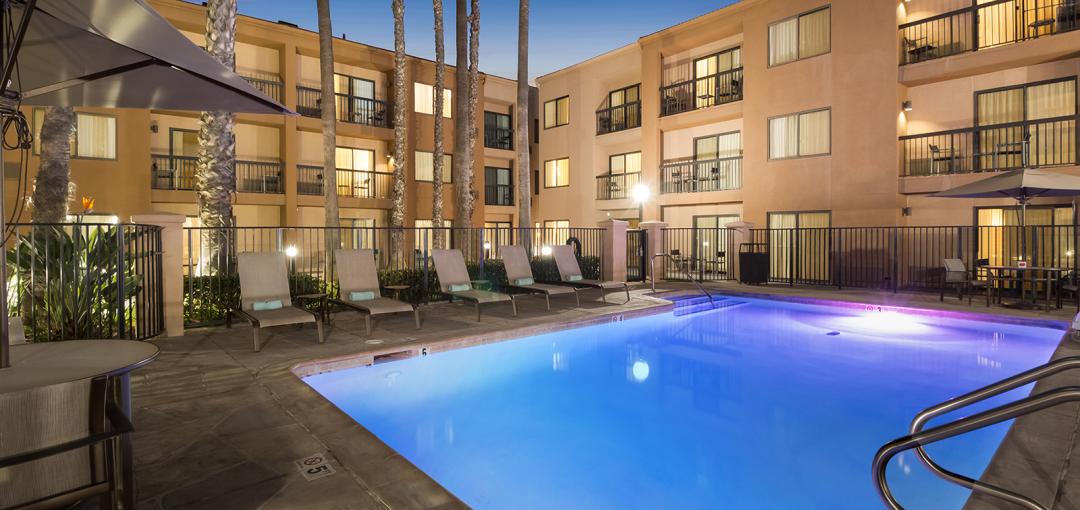 The exterior & pool area of the Sonesta Select Huntington Beach Fountain Valley hotel.