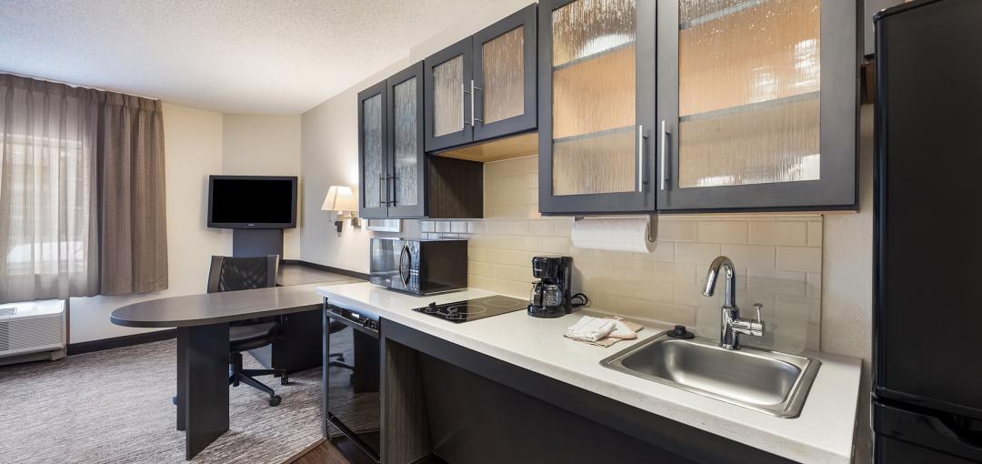 A room with a kitchenette at the Sonesta Simply Suites Denver West Federal Center hotel.