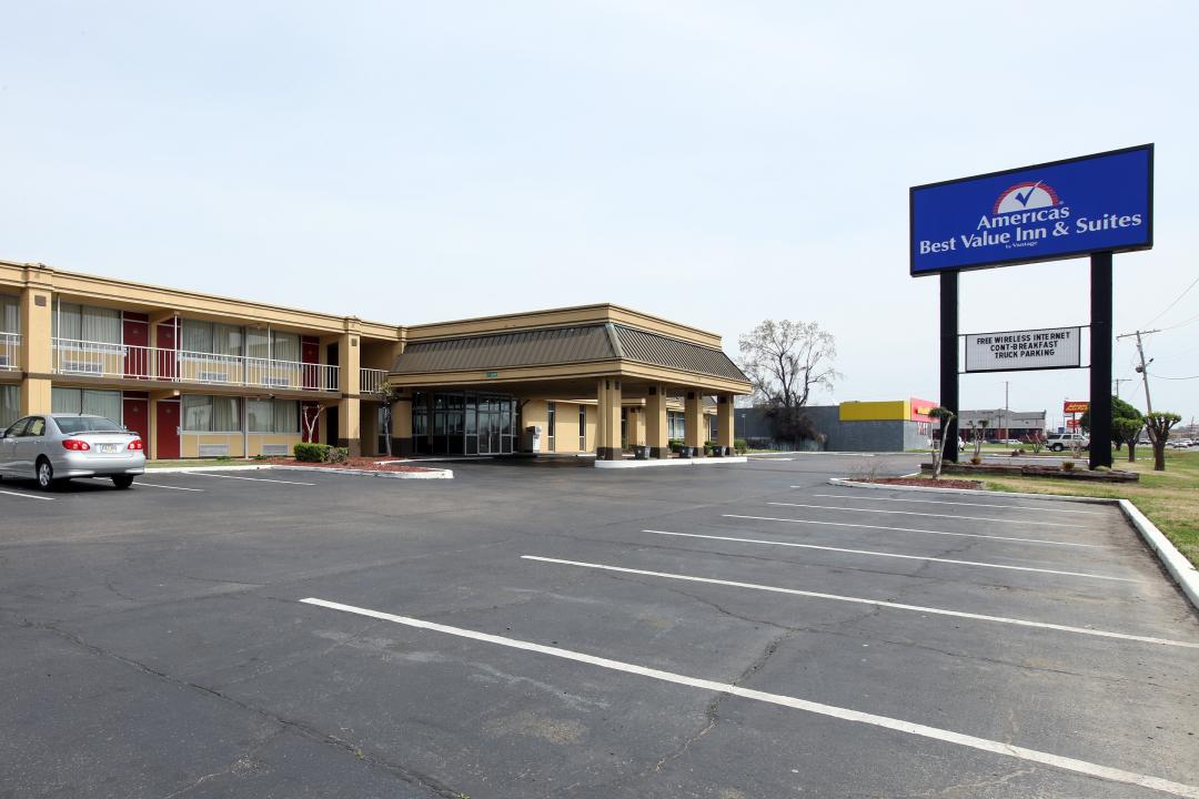 Hotel parking lot with sign and exterior corridors 