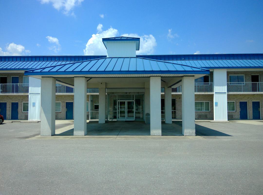 Front Exterior with driveway to lobby, blue roof
