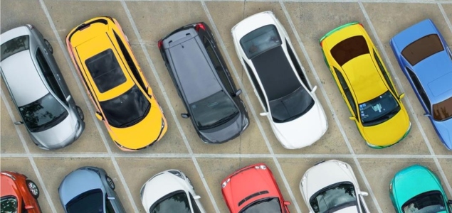 Aerial view looking down at cars perked in a parking lot.