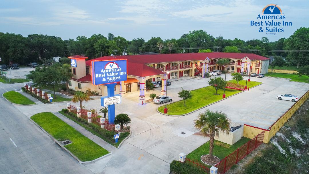 Bird-eye view of hotel exterior with parking and lawn area