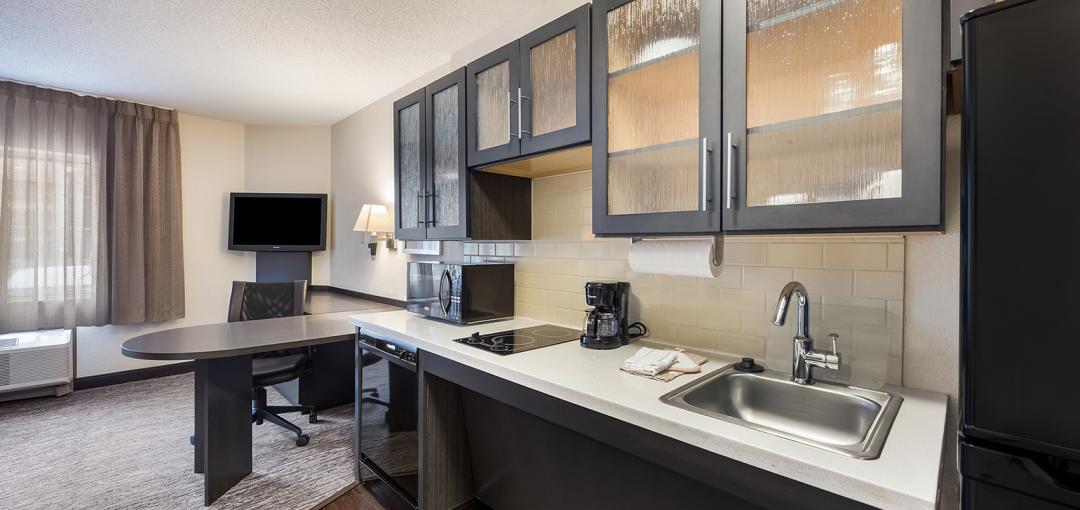 A studio room with a kitchen at the Sonesta Simply Suites Salt Lake City Airport hotel.