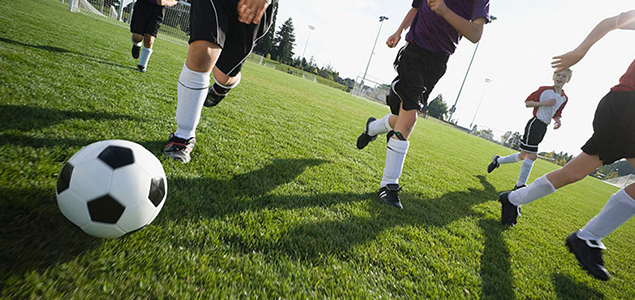 Sports Certified Group Travel initiative for Sonesta hotels, image of male soccer players in the middle of a game on a grass field